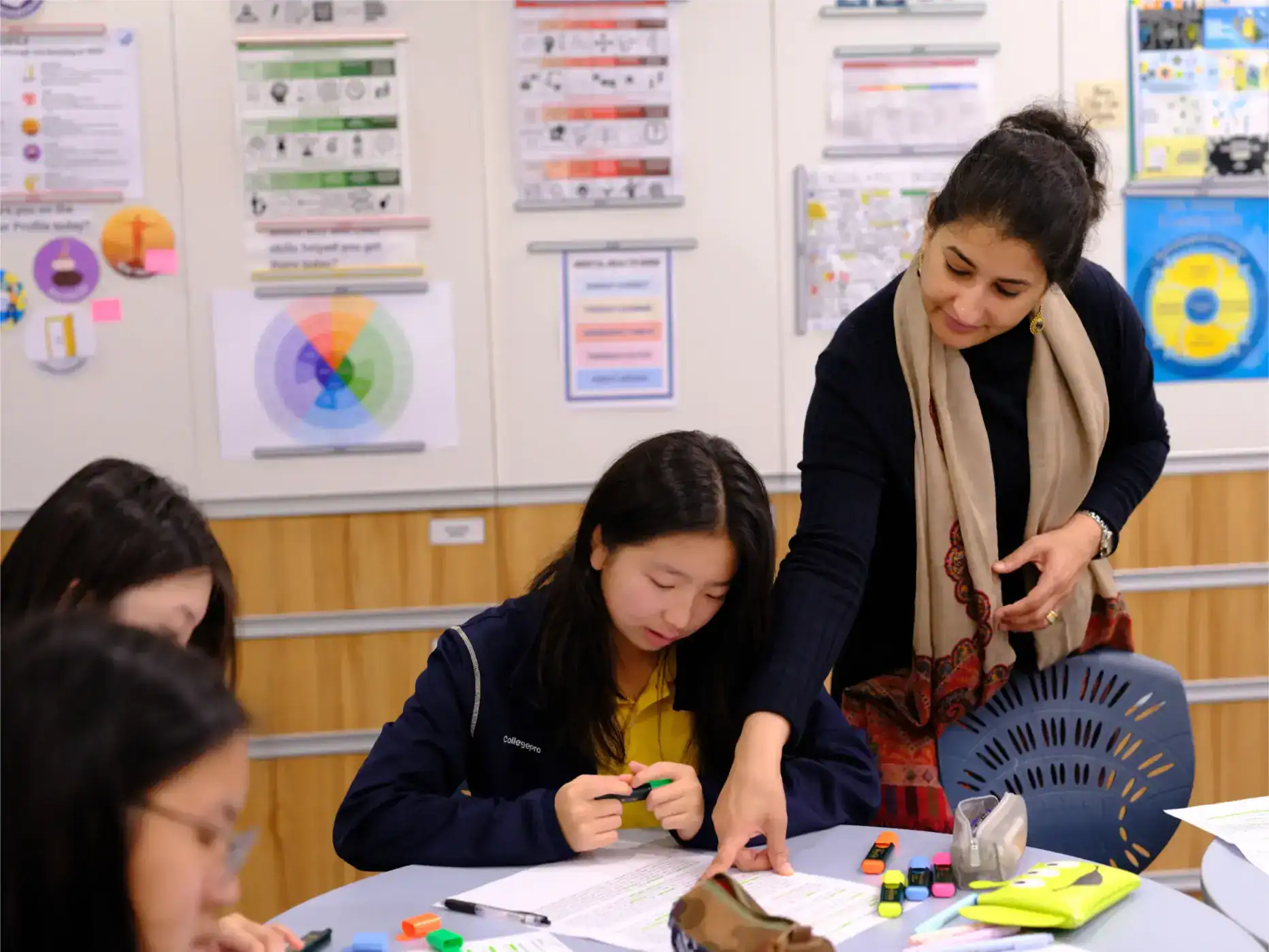 Focused teacher assisting student with classroom activity, educational environment, learning support, school collaboration, diverse students, academic success, classroom setting, student engagement, teaching, school education.