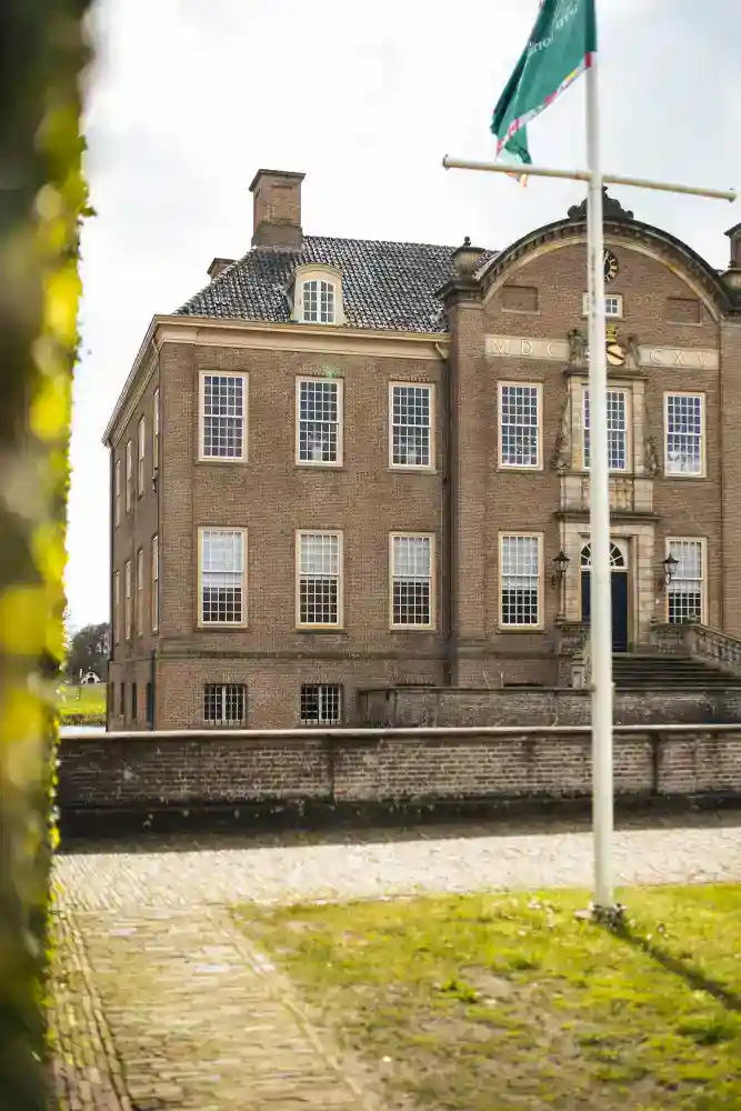 Historic European-style school building with classic architecture and lush surroundings.