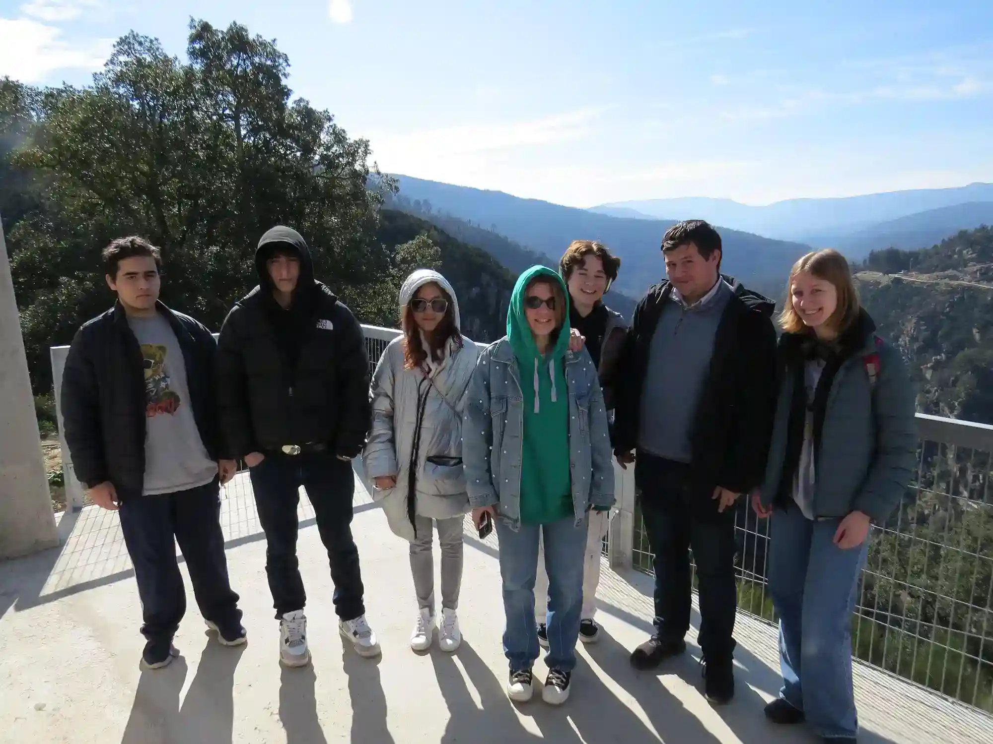 Students on a scenic mountain overlook during an educational trip at a world school.