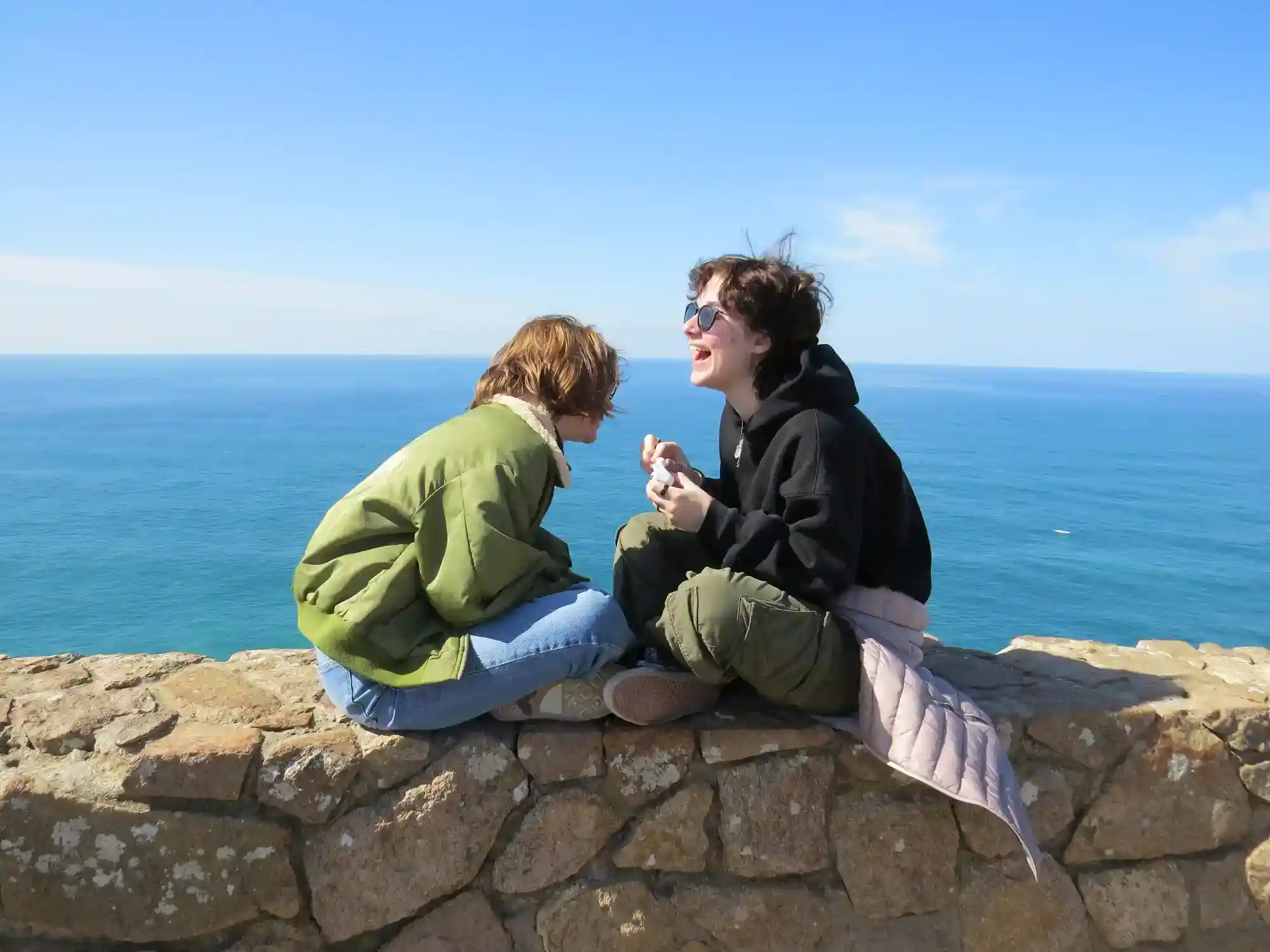 Young friends enjoying outdoor scenery by the coast, representing vibrant school life at World Schools.