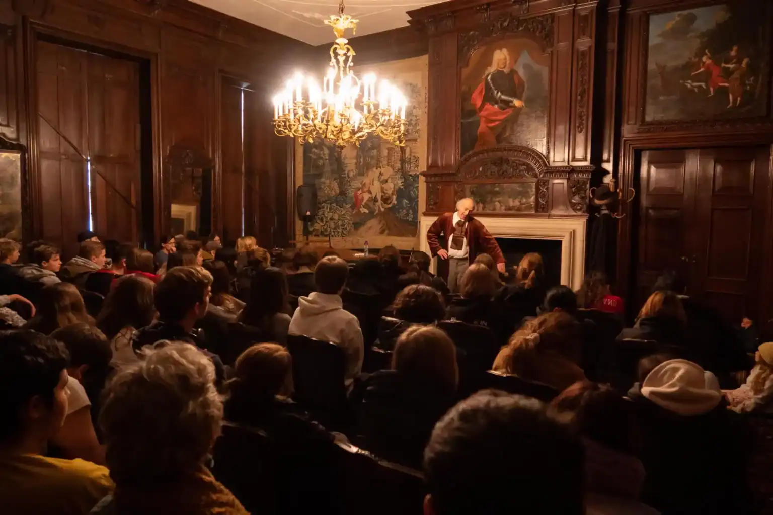 Elegant historic school auditorium with students attending a lecture or presentation.