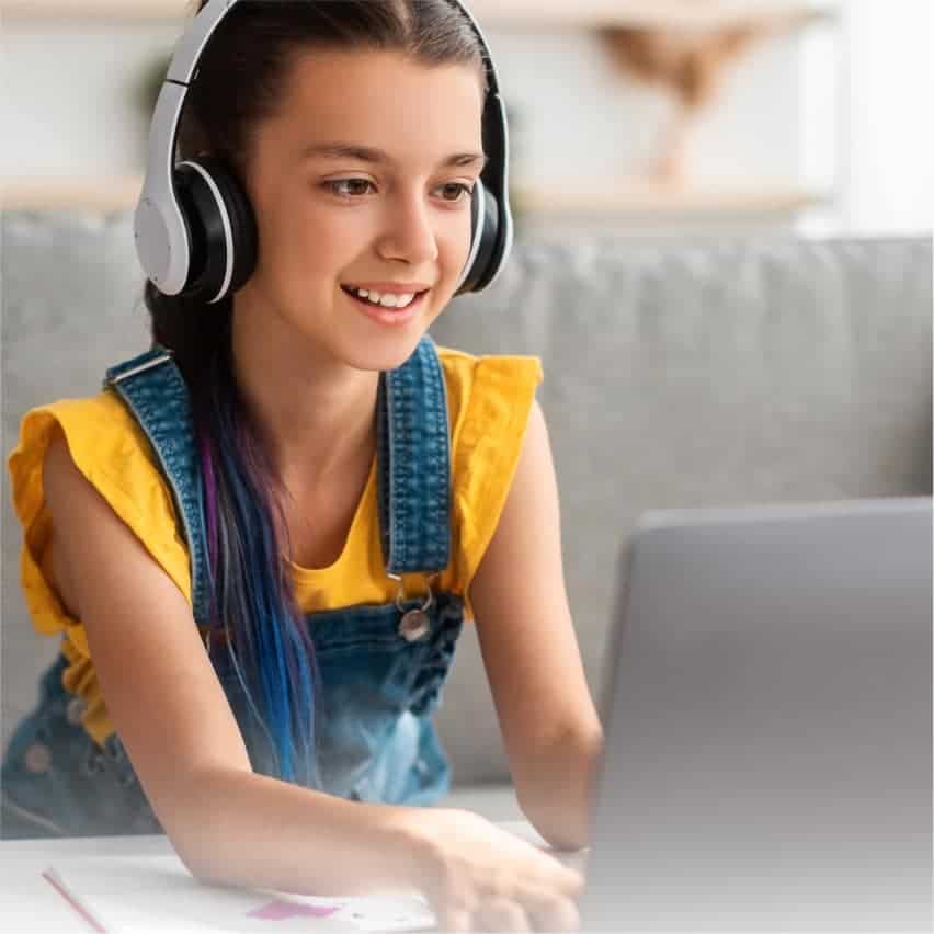 Young girl studying online with headphones, engaging in virtual learning, representing innovative world schools and global education.