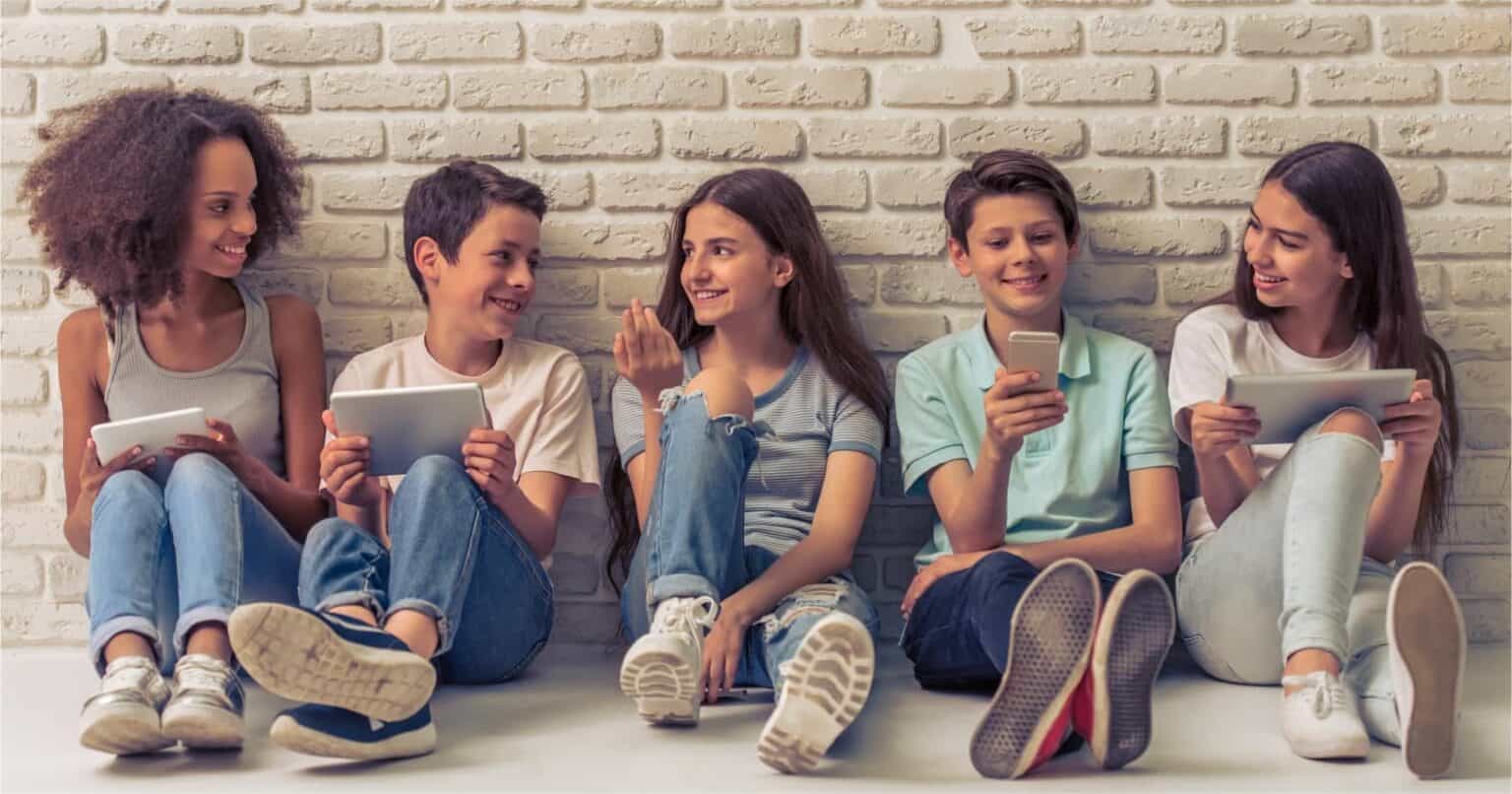 Children using tablets and smartphones in a modern school setting, promoting digital learning and innovative education.