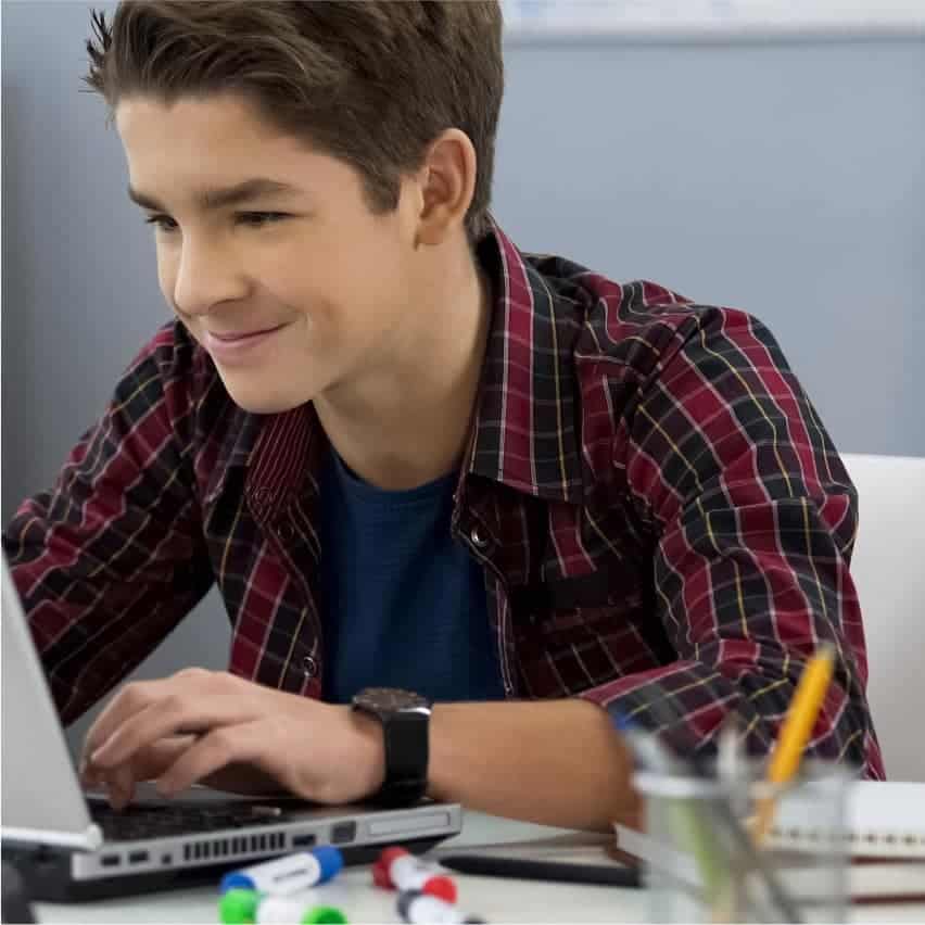 Motivated student studying with laptop at school or home, fostering academic success and skills for future opportunities.