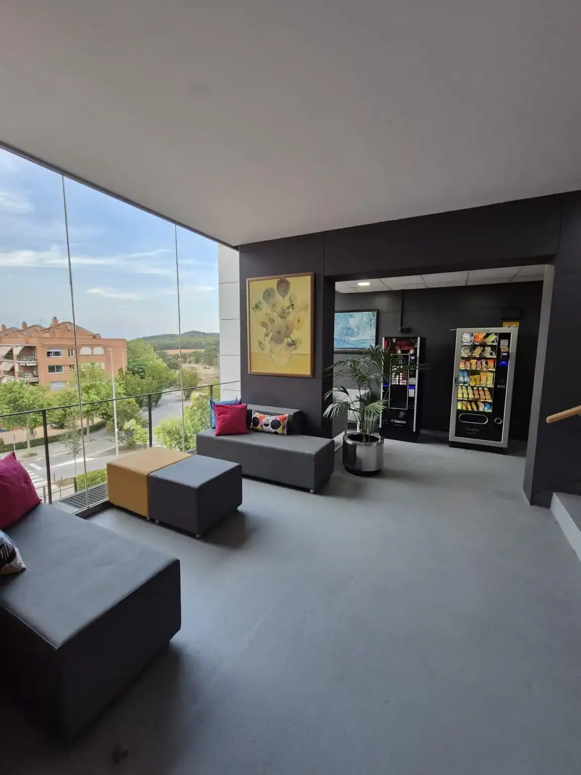 Bright modern school lounge with large windows and vending machines for student comfort.