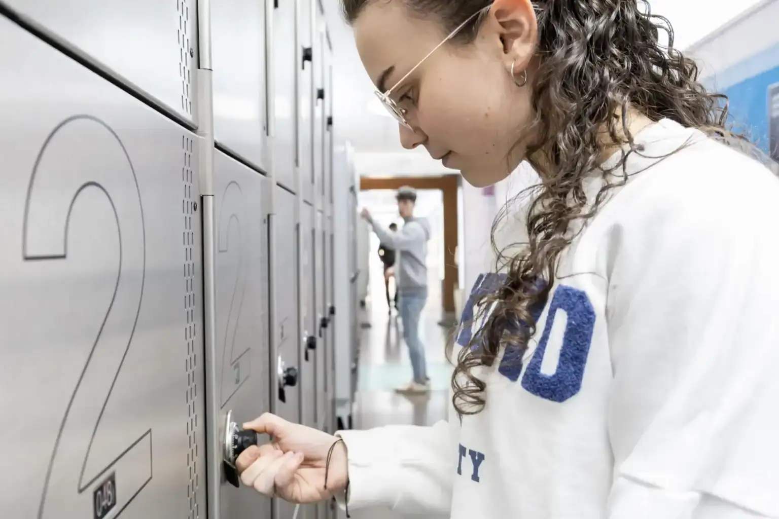 Lockers in a modern school hallway with students, emphasizing innovative education environments.