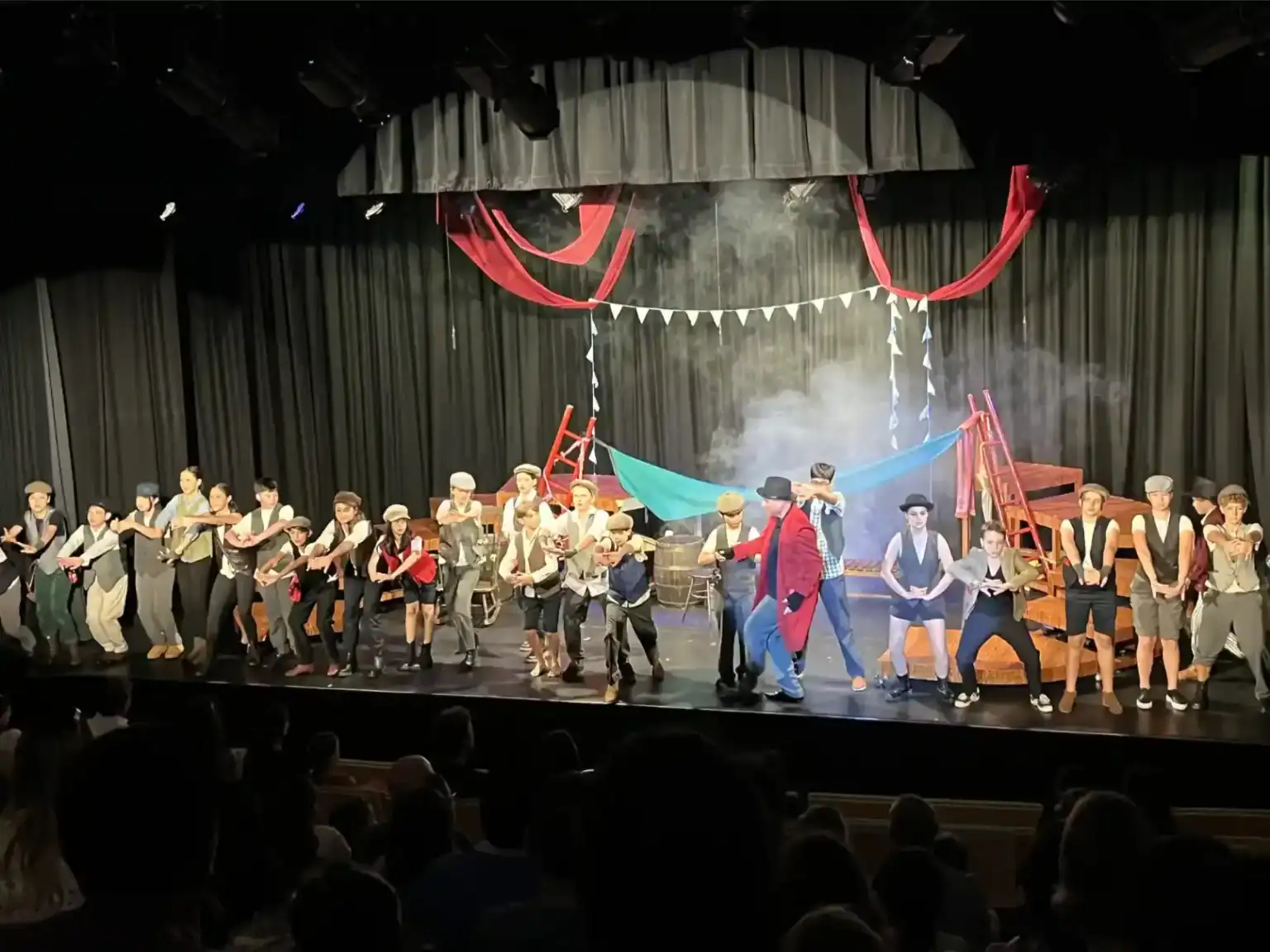 Vibrante representación teatral escolar con los alumnos disfrazados en el escenario, que pone de manifiesto la creatividad y el trabajo en equipo.