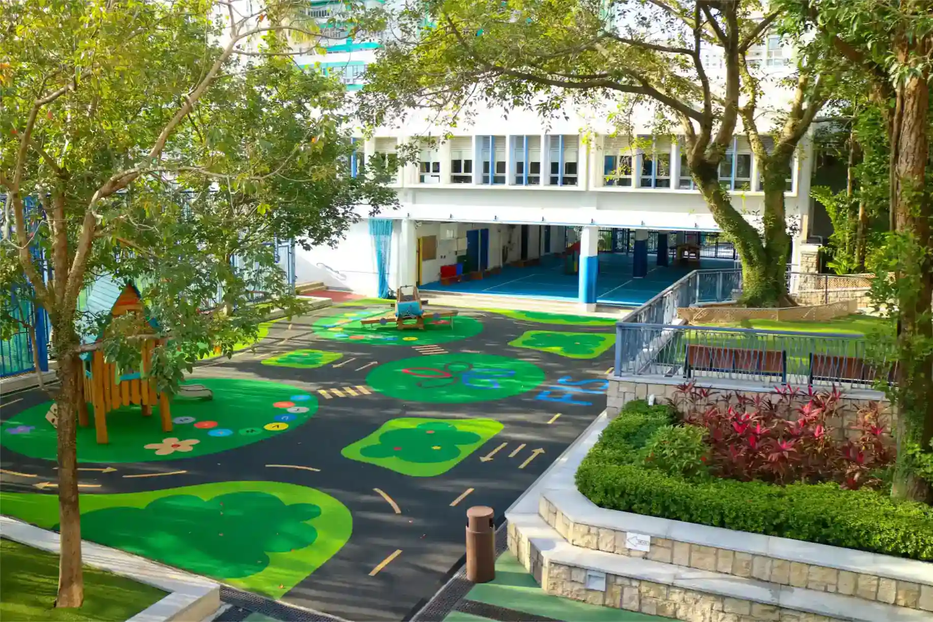 Luminoso y colorido patio de recreo al aire libre en un colegio internacional de categoría mundial con frondosos árboles y modernas instalaciones.