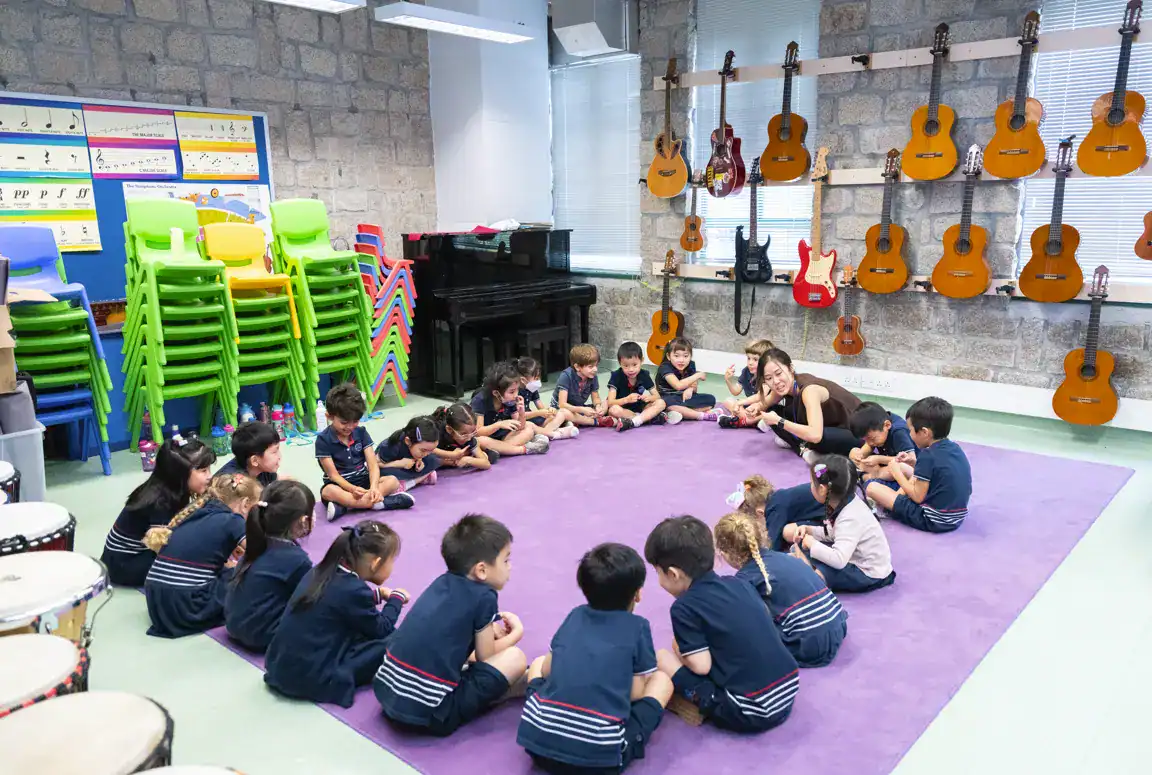 Colorida aula con instrumentos musicales y jóvenes alumnos participando en una actividad de grupo en los Colegios del Mundo.