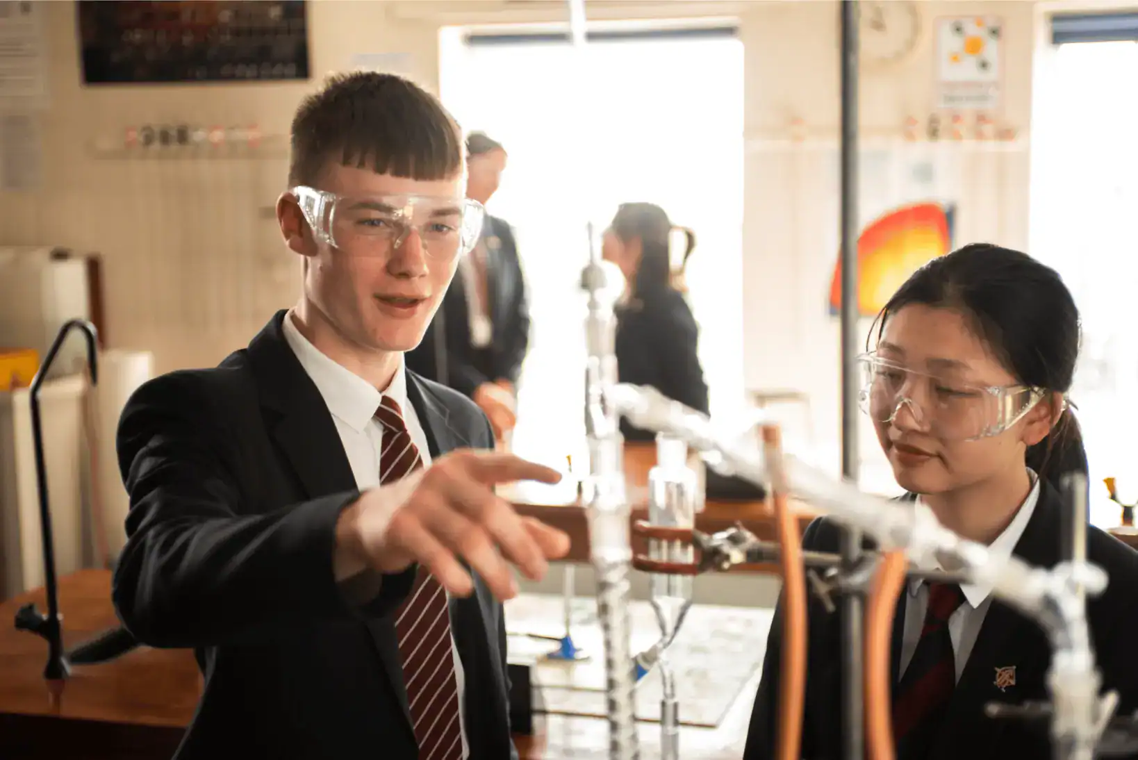Giovani studenti che conducono esperimenti scientifici in un laboratorio scolastico, che enfatizza l'educazione innovativa delle Scuole Mondiali.