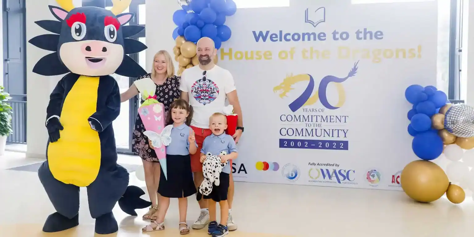 Colorful mascot and family celebrating at World Schools' 20th anniversary event.