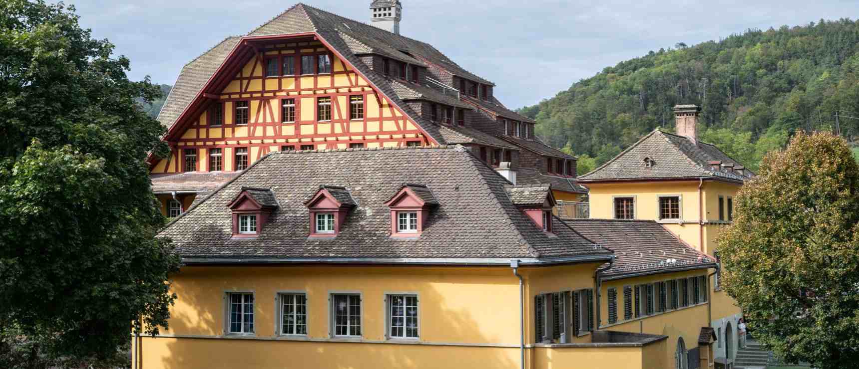 Traditional European-style school building with colorful architecture and surrounding greenery.