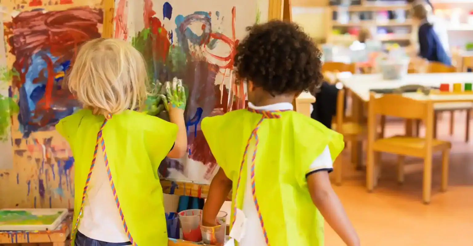 Farbenfrohe Kinder malen kreativ in einem Kunstkurs an einer internationalen Schule.