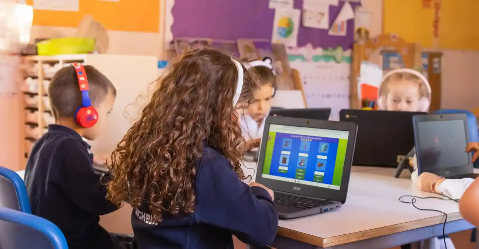 Schüler nutzen Laptops in einem Klassenzimmer für innovatives Lernen an Weltschulen.