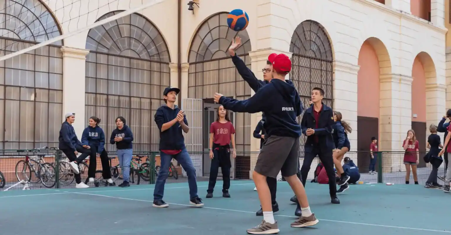 Junge Schüler spielen Basketball auf dem Schulhof und treiben Sport an Weltschulen.