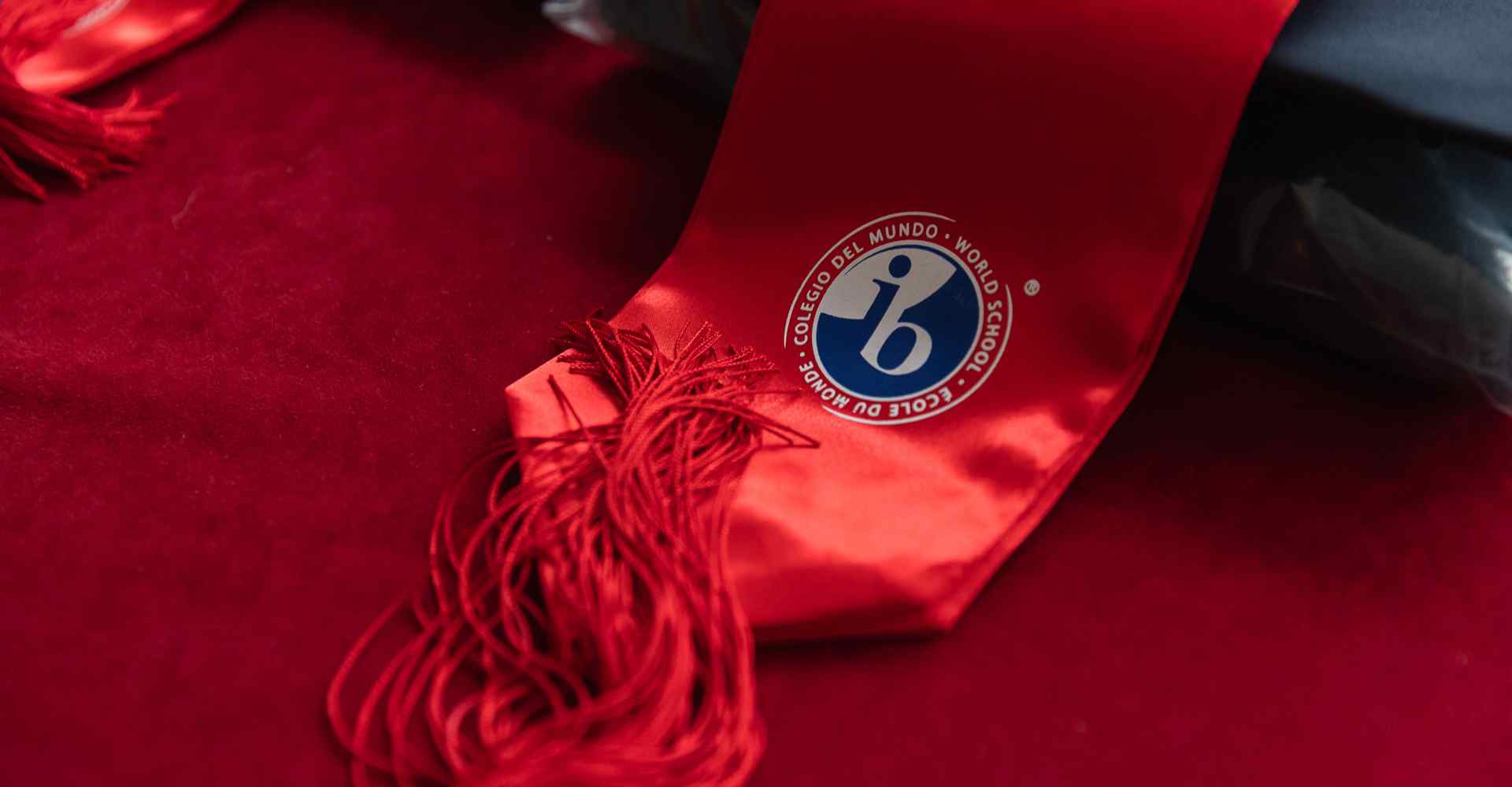 Internationales Abiturdiplom (IB) mit rotem Satinband, das in Bildungssystemen von Weltrang verwendet wird.