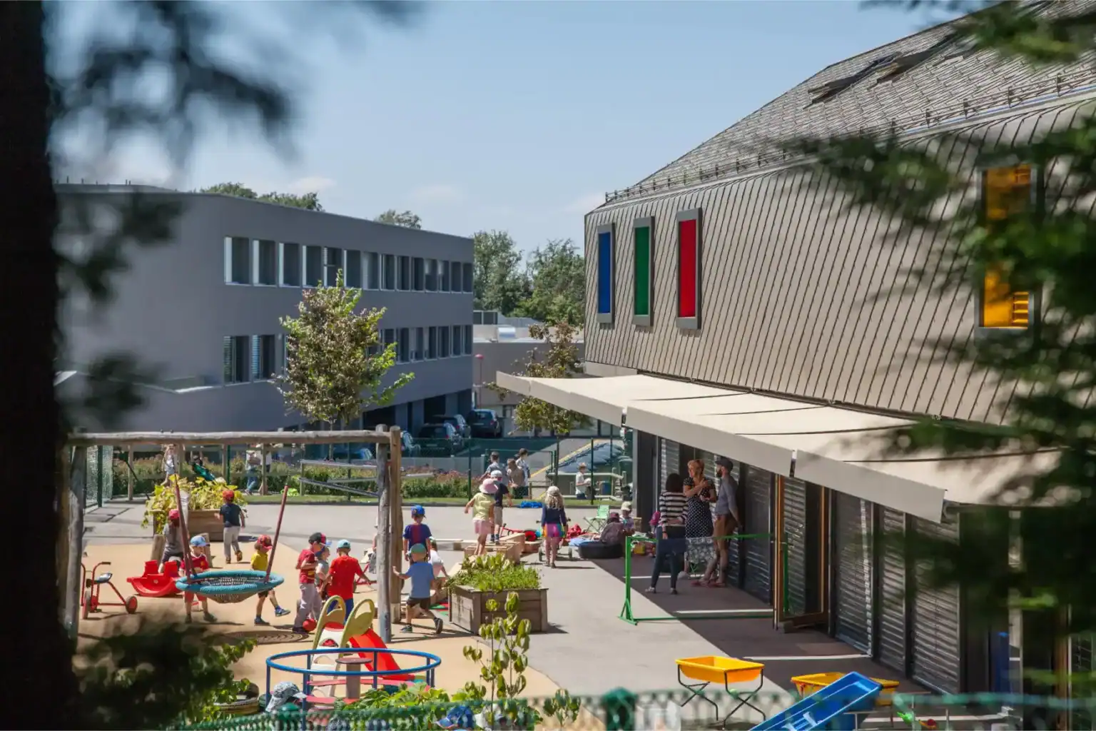 Vibrant school playground at a modern international school with children playing, surrounded by contemporary architecture.