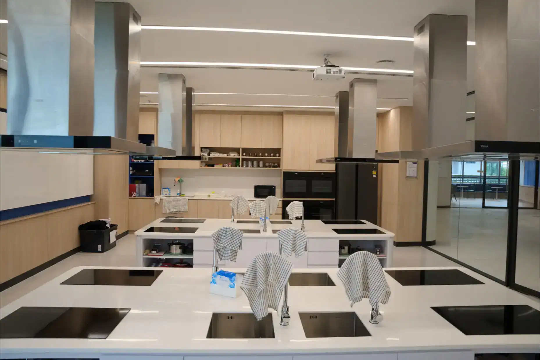 Modern school kitchen with multiple cooking stations and sleek design, ideal for student culinary programs.