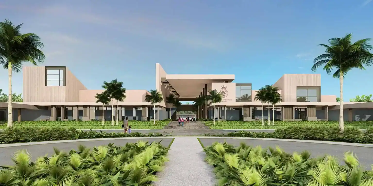 Modern school building with lush green landscaping and palm trees, ideal for international student education.