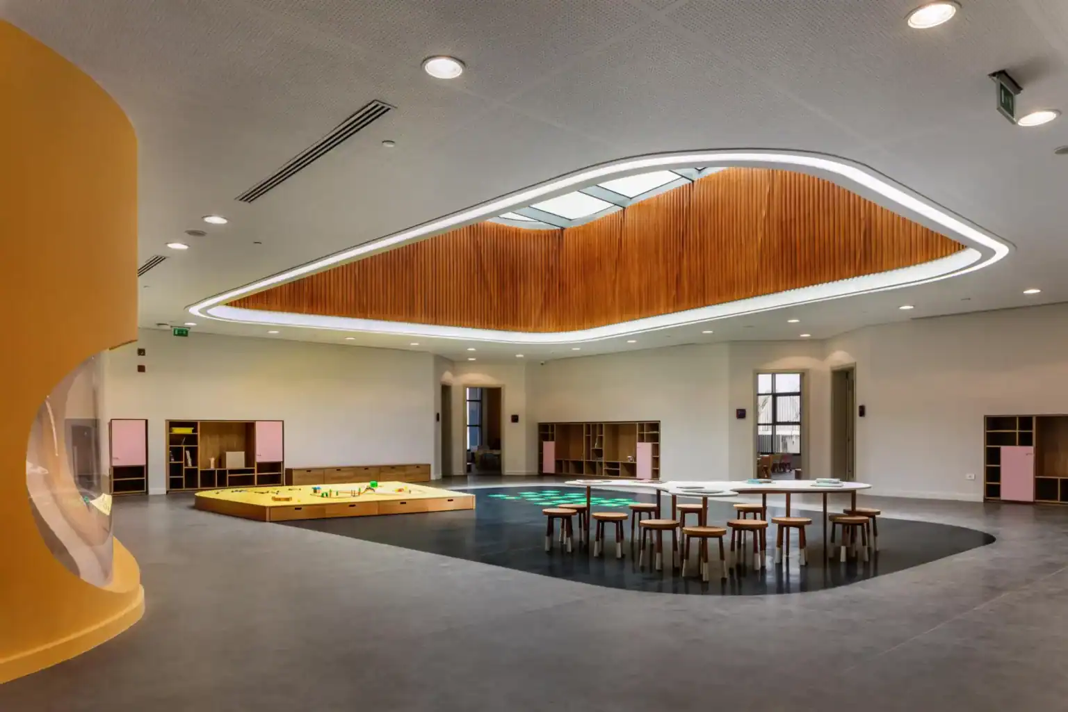 Bright modern school interior with colorful learning spaces and wooden accents for innovative education.