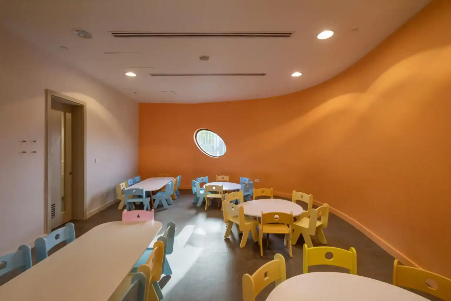 Bright, colorful classroom with child-sized tables and chairs at a world schools facility.