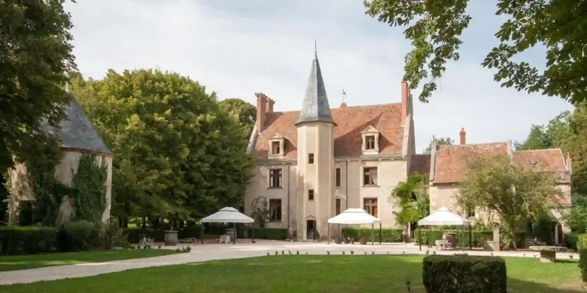 Elegant European-style school building with lush green surroundings and outdoor seating area.
