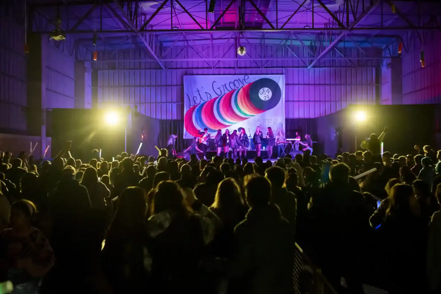 大きな屋内体育館で行われる、にぎやかなスクールコンサートやタレントショーに出演する生徒たち。.