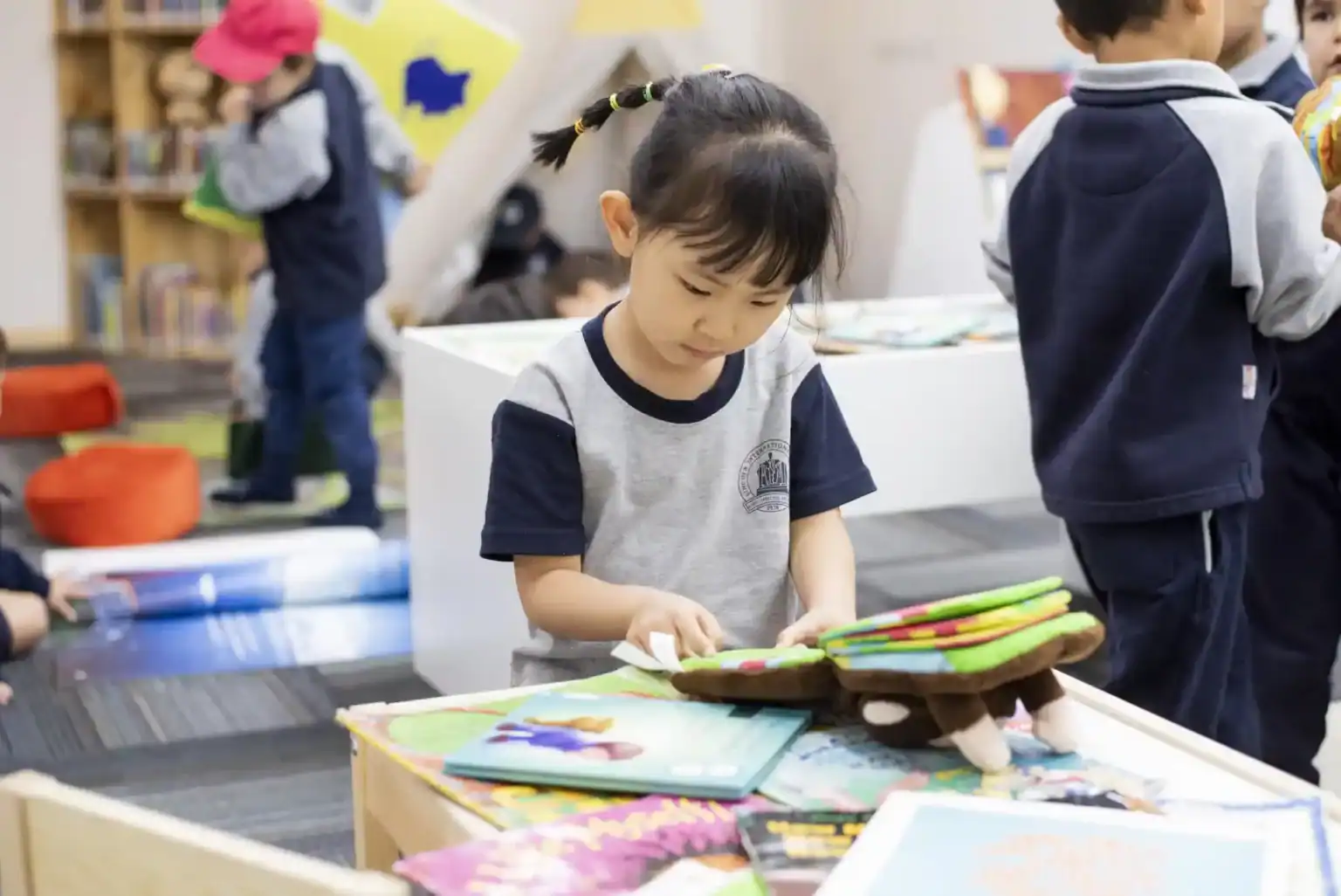幼児教育のための活気ある学校図書館で本を探索する明るい少女。.