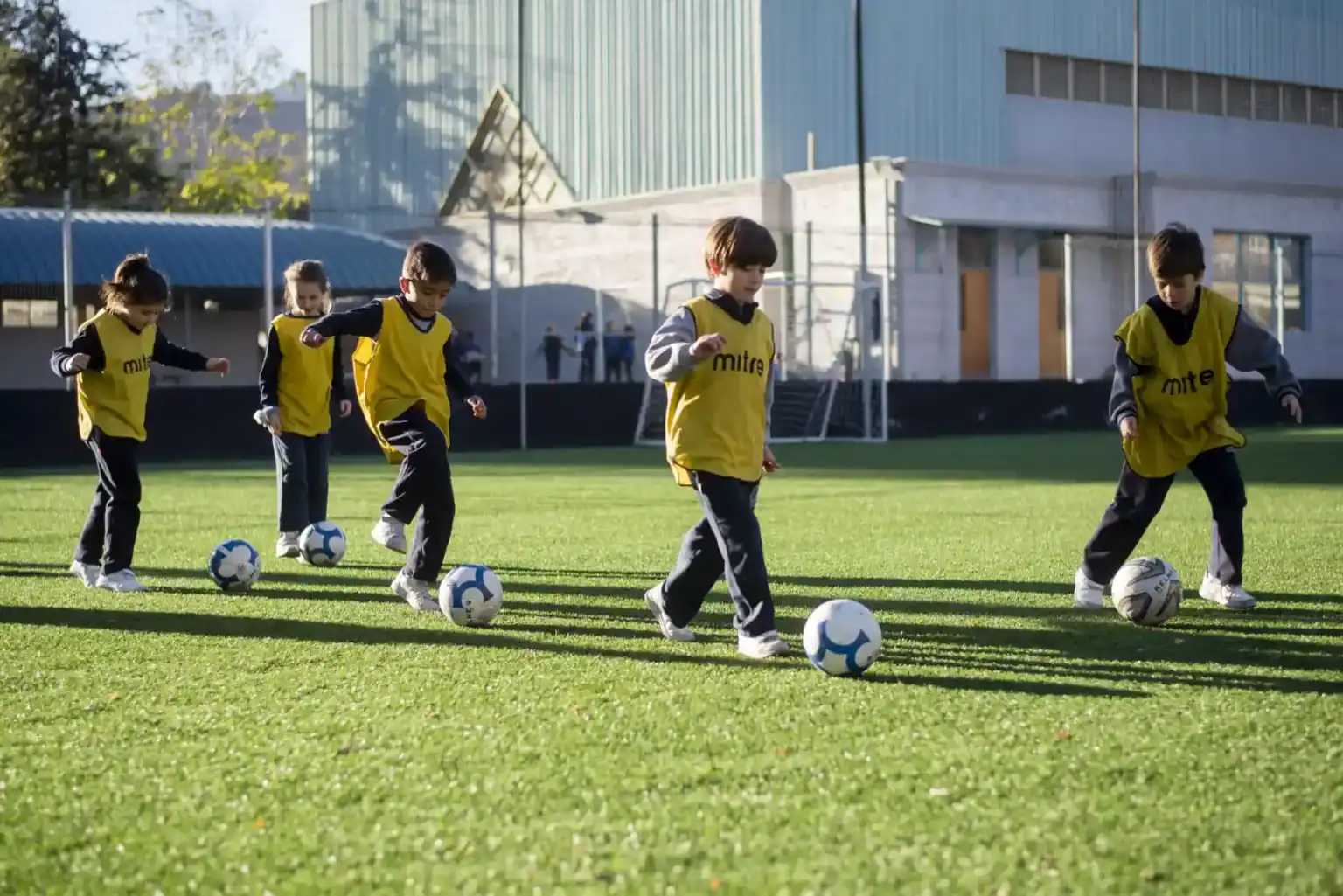 学校のグラウンドでサッカーの練習をする子どもたち。.