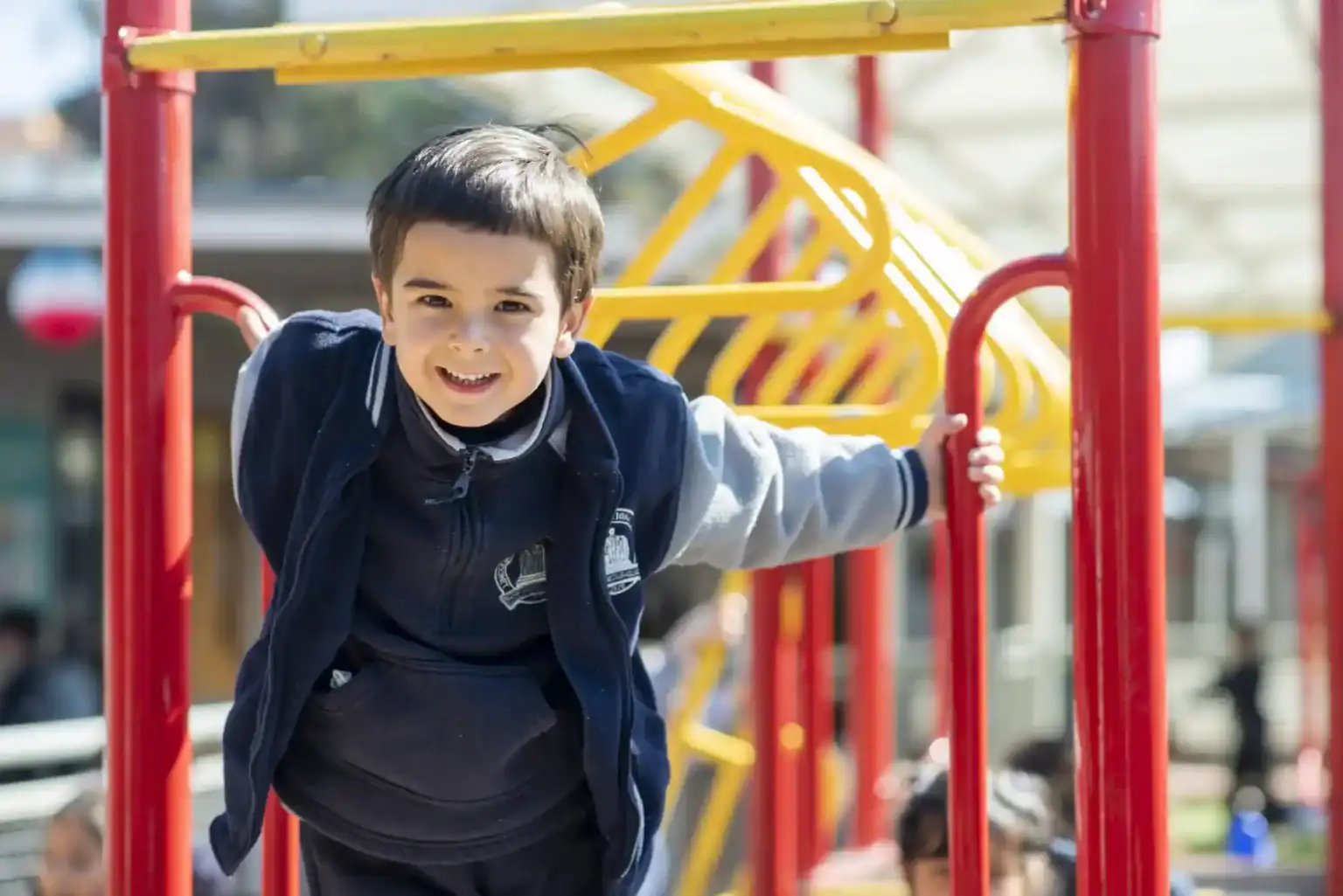 アクティブ・ラーニングと生徒の幸福を促進する、野外での学校活動を楽しむ笑顔の少年とカラフルな運動場。.