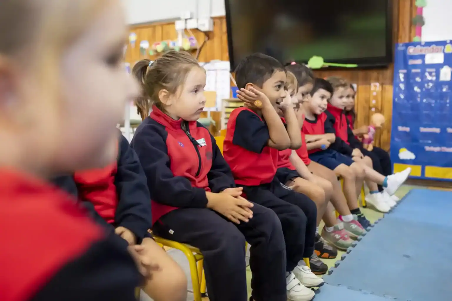 グローバルな学校コミュニティの一員として、学習に集中する教室で、注意深く座っている幼い子どもたち。.