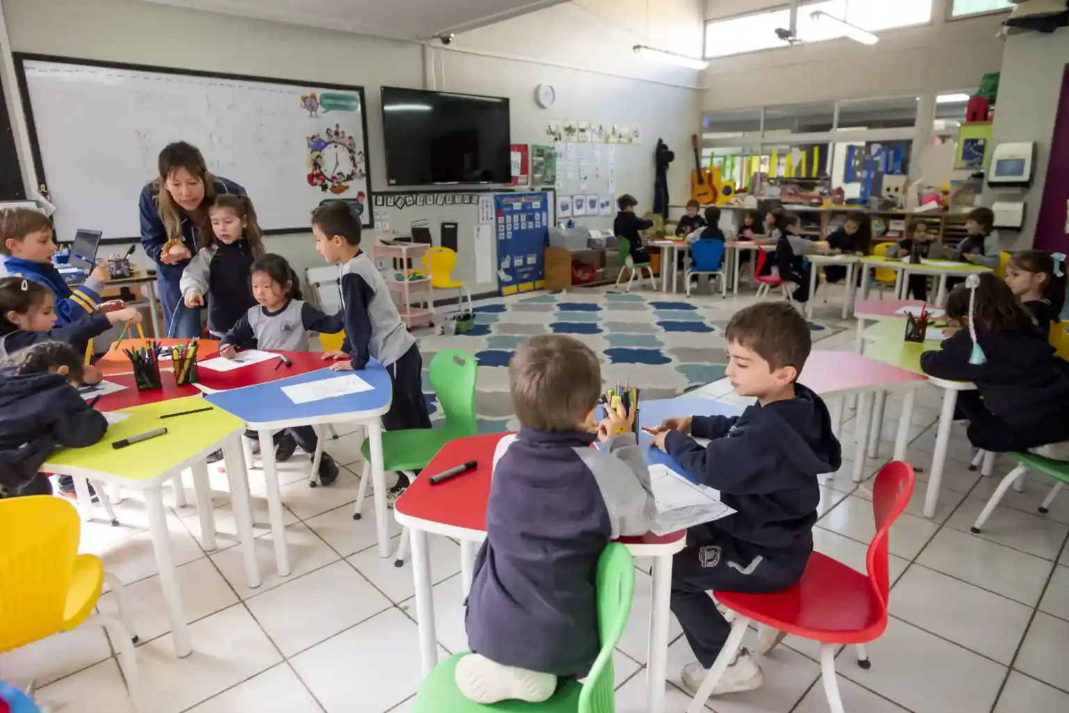 ワールド・スクールの明るい教室では、若い生徒たちが最適な教育のための学習活動に取り組んでいる。.