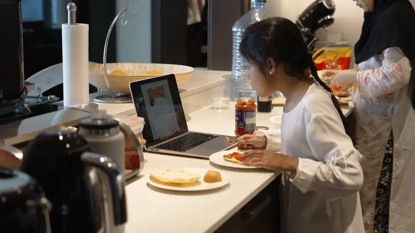 Children cooking with a tablet in the kitchen at World Schools.