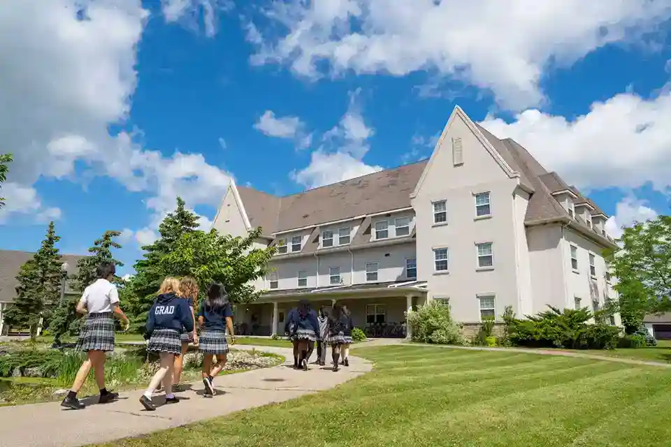 Bright school campus with students in uniform walking outside, emphasizing world school environment and academic excellence.