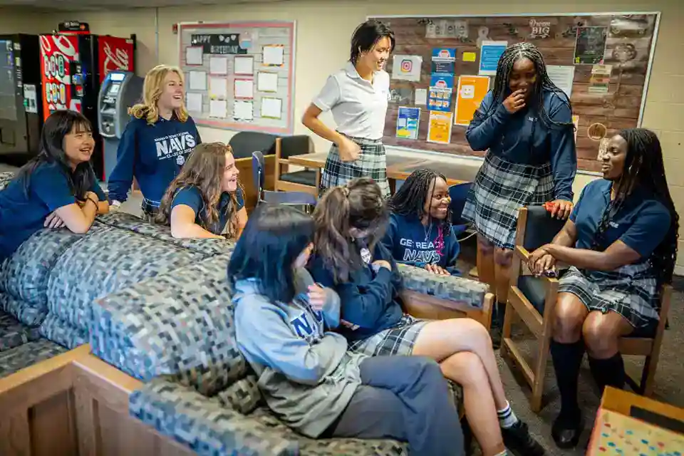 Cheerful group of diverse students and teachers enjoying classroom interaction at World Schools.