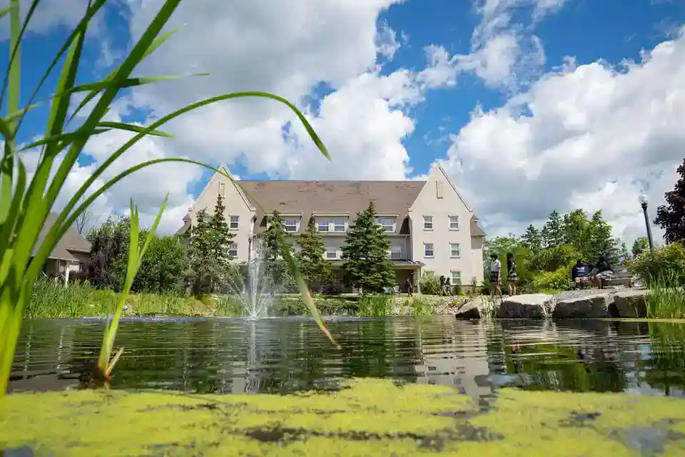 Modern educational campus with lush greenery and water features for optimal student learning environments.