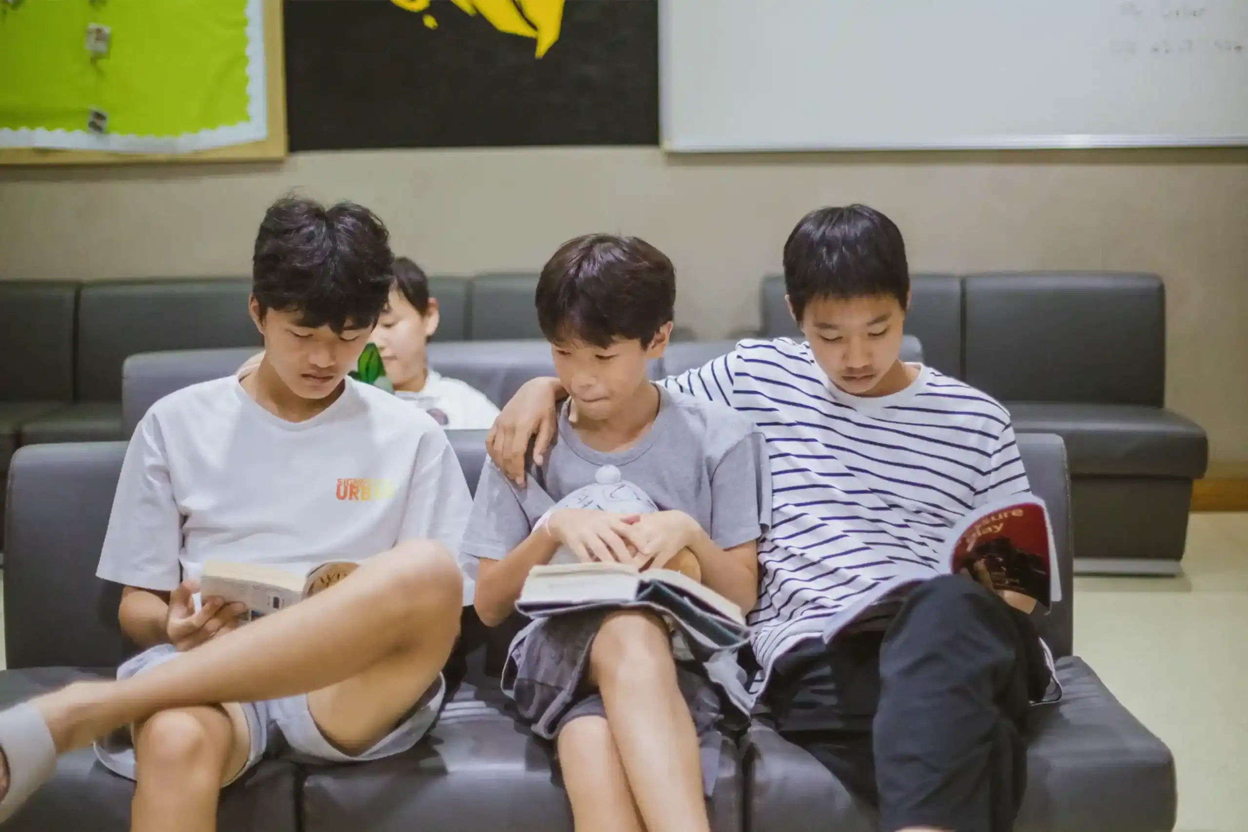 Young students reading books in classroom, focused on learning and education at World Schools.