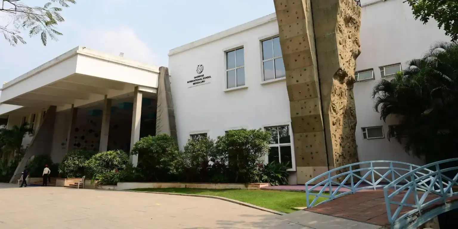 Kaliteli eğitim ve müfredat dışı etkinlikler sunan, tırmanma duvarı ve yemyeşil bir alana sahip modern uluslararası okul binası.