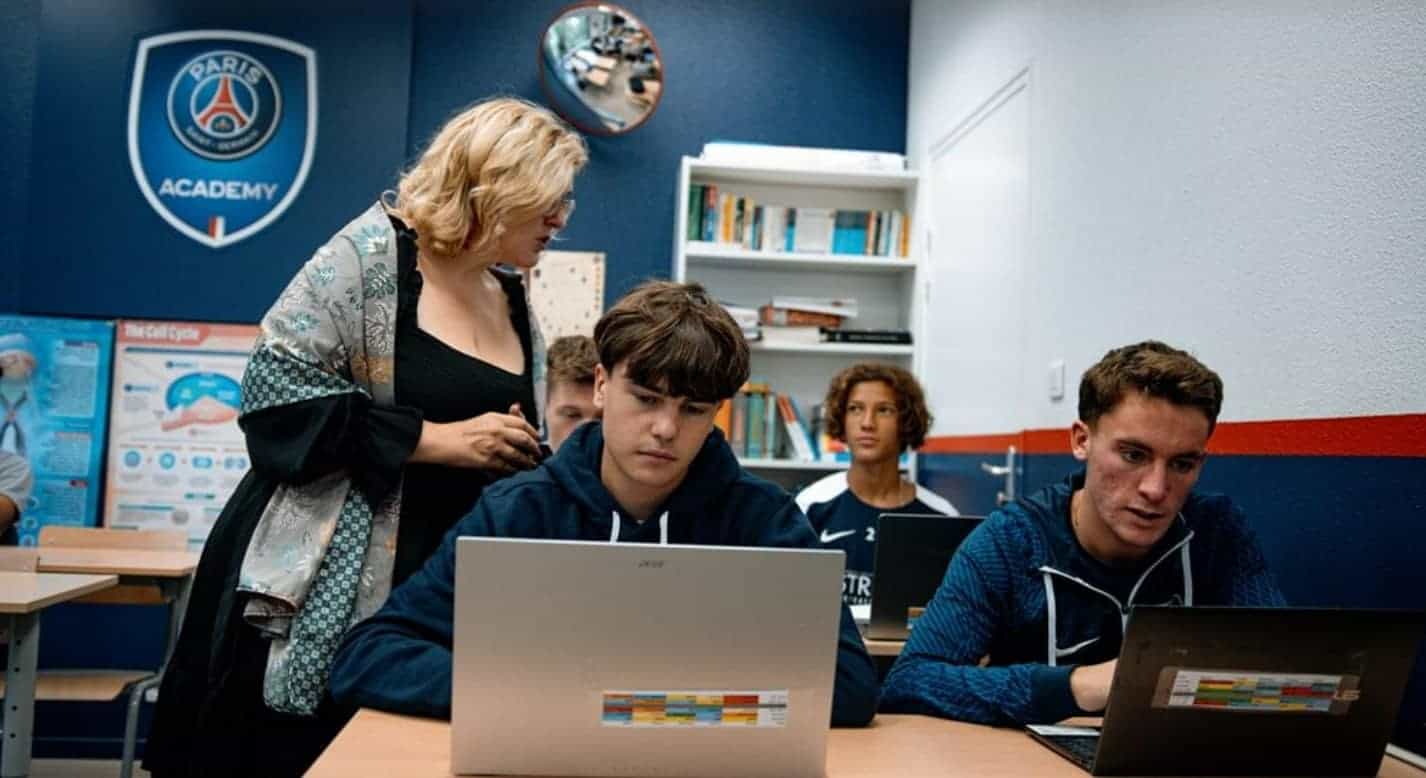 Innovative World Schools learning environment with students using laptops in classroom setting.