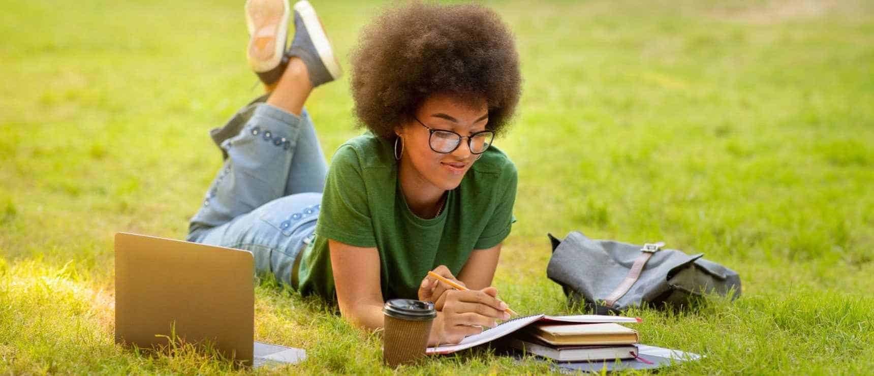 Bright young student studying outdoors at a world school campus for optimal education.