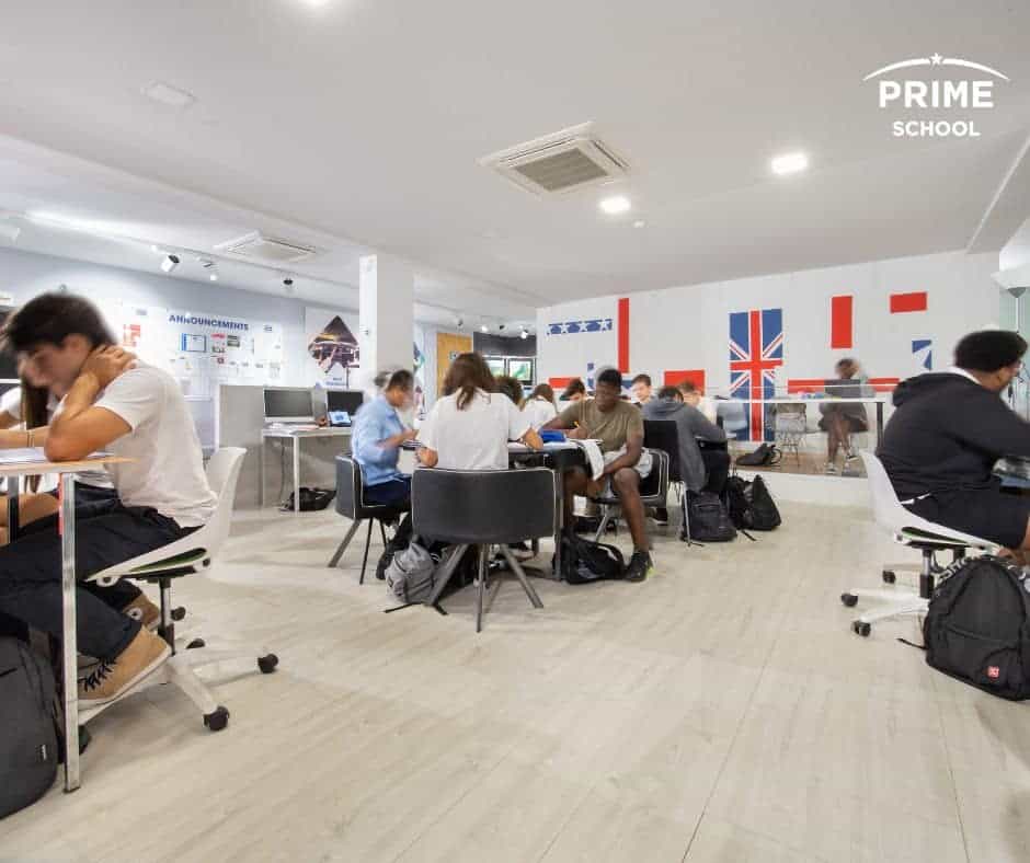 Focused students studying in a modern classroom at a World Schools institution with British flags, promoting global education excellence.