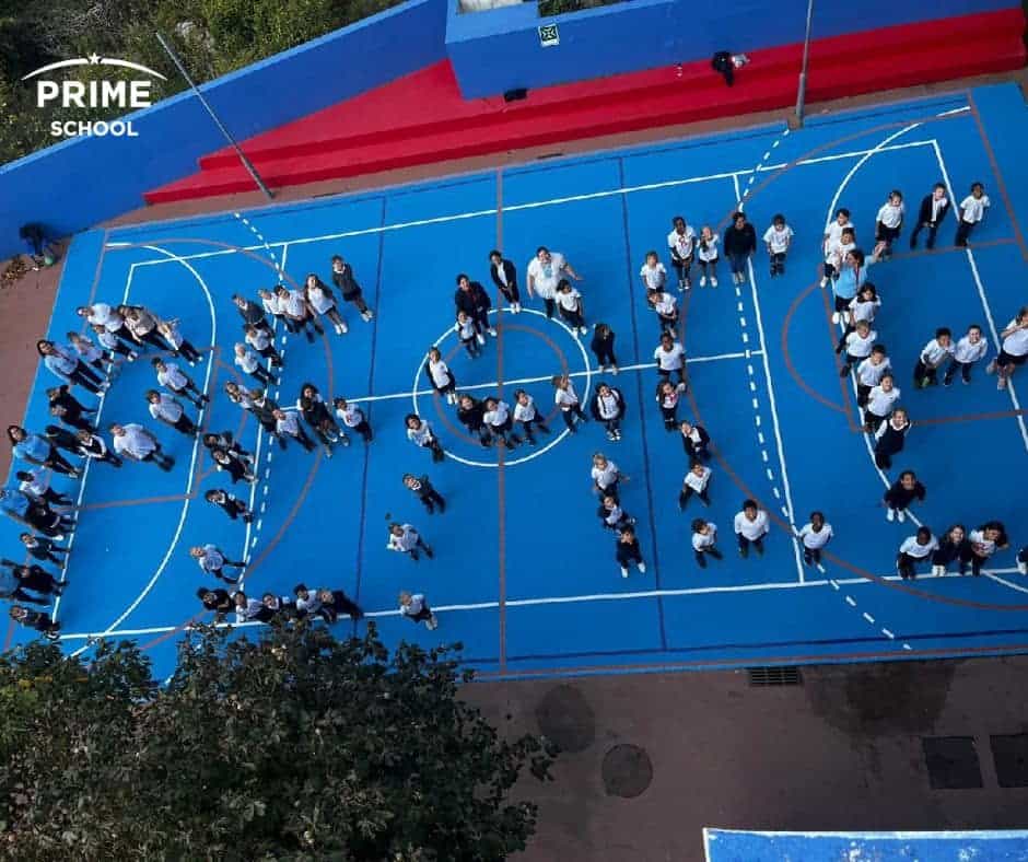 Students standing on an outdoor basketball court at Prime School, part of World Schools network, fostering global education and leadership.