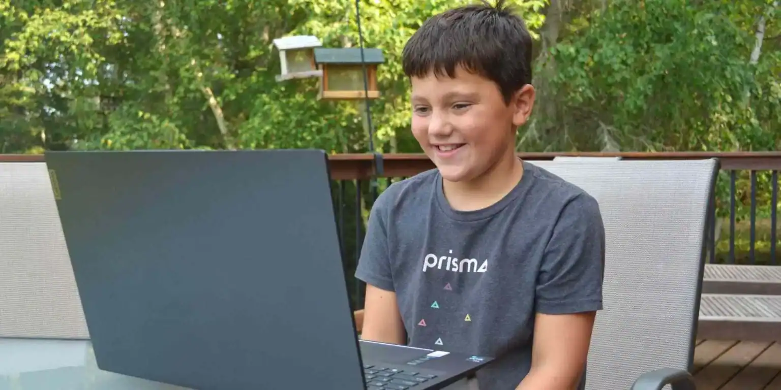 Dünya okullarında yenilikçi eğitimi temsil eden dizüstü bilgisayar kullanan genç bir çocukla açık havada öğrenme.