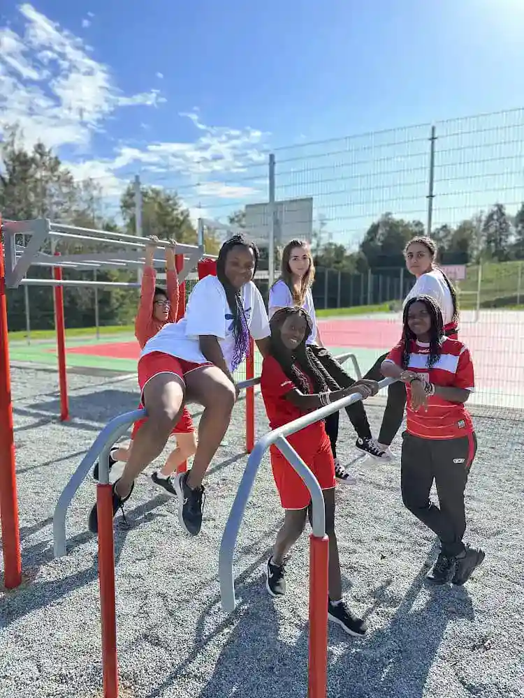 1. Diverse group of students exercising outdoors on fitness equipment at a world school.