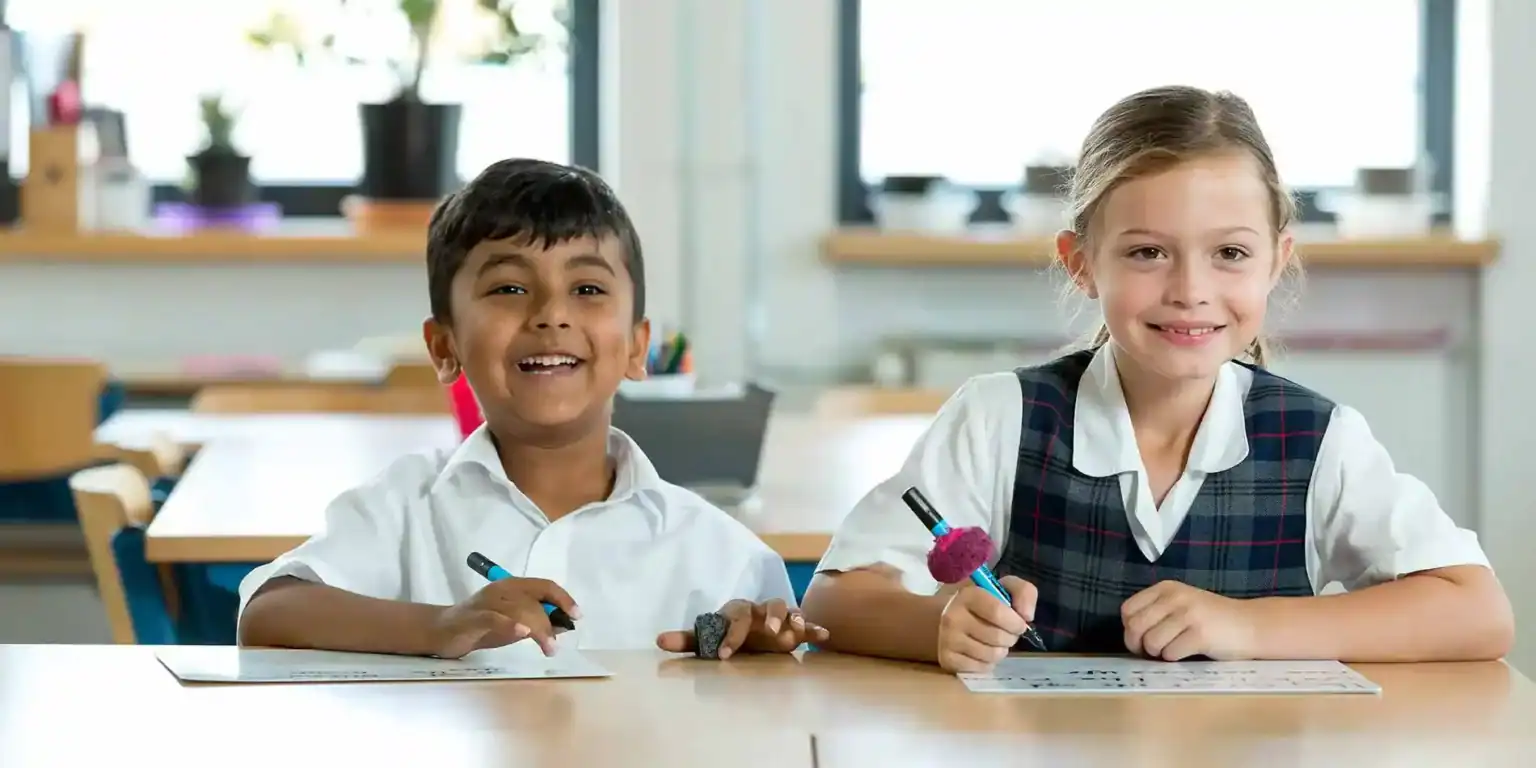 Bright young students smiling in classroom at an international school in a vibrant learning environment.