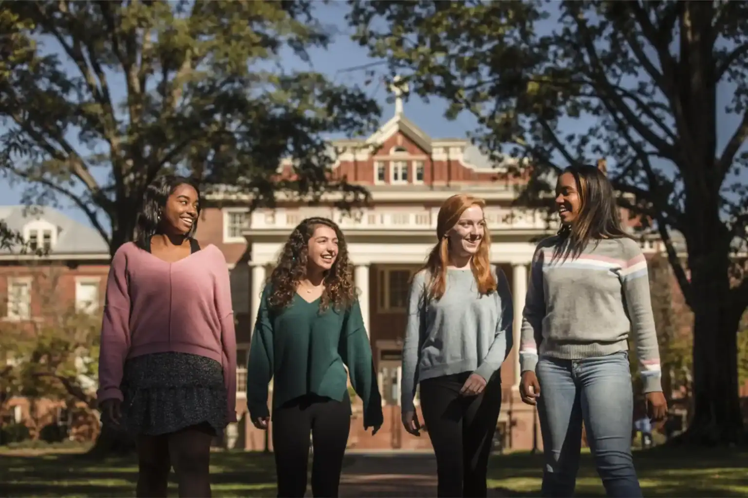 Bright diverse students walking on school campus, enjoying learning environment at world-class international school.