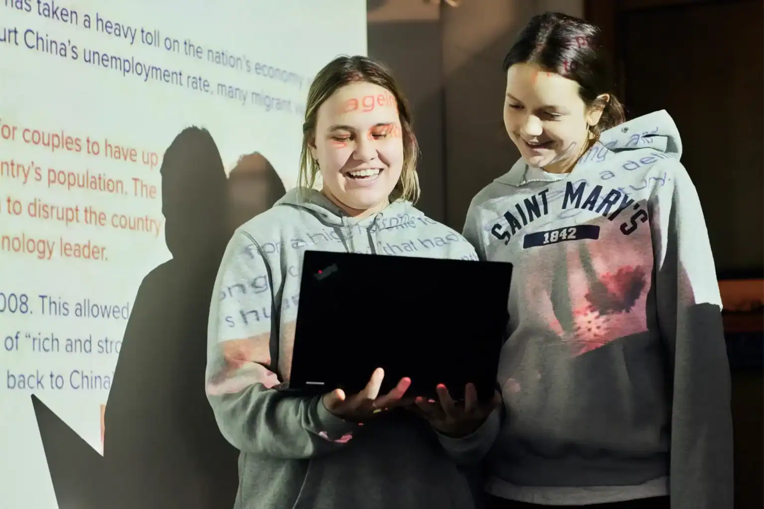 Young students using a laptop during a classroom presentation at a world school.