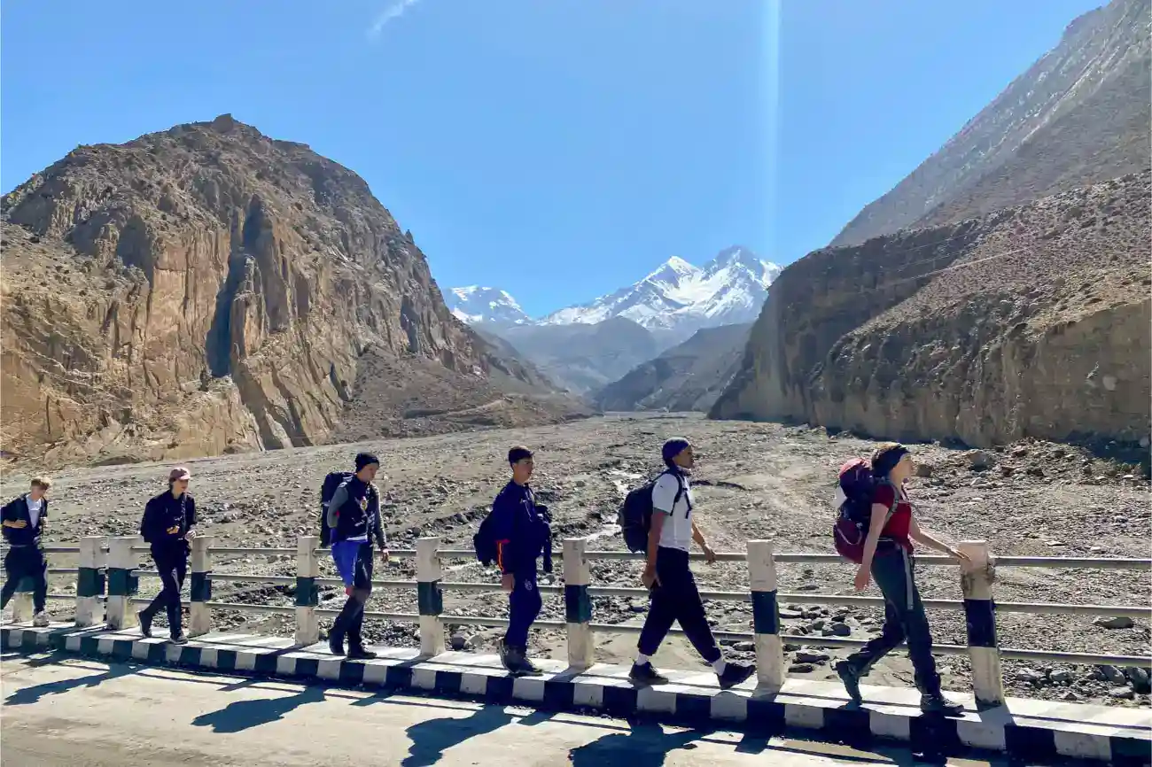 This Year at TASIS: 2023 10 Students hiking in the Himalayas, exploring nature in a scenic mountainous landscape.