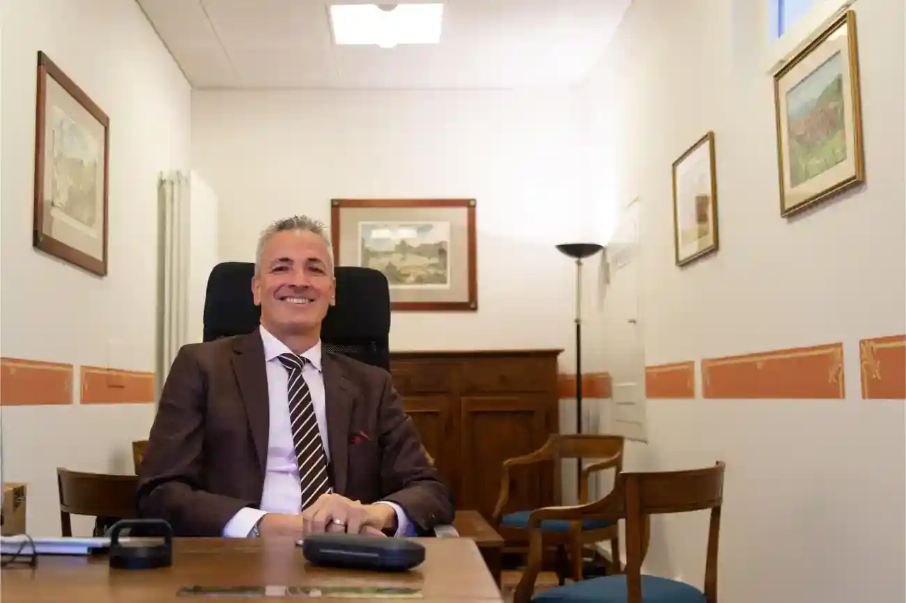 This Year at TASIS: 2023 2 High-level professional man sitting at a desk in an office, representing leadership in international schools.