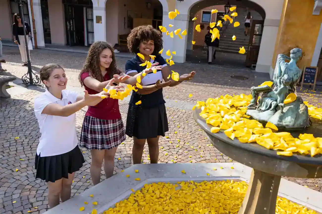 This Year at TASIS: 2023 37 Bright students celebrating school tradition with yellow flower petals at World Schools.